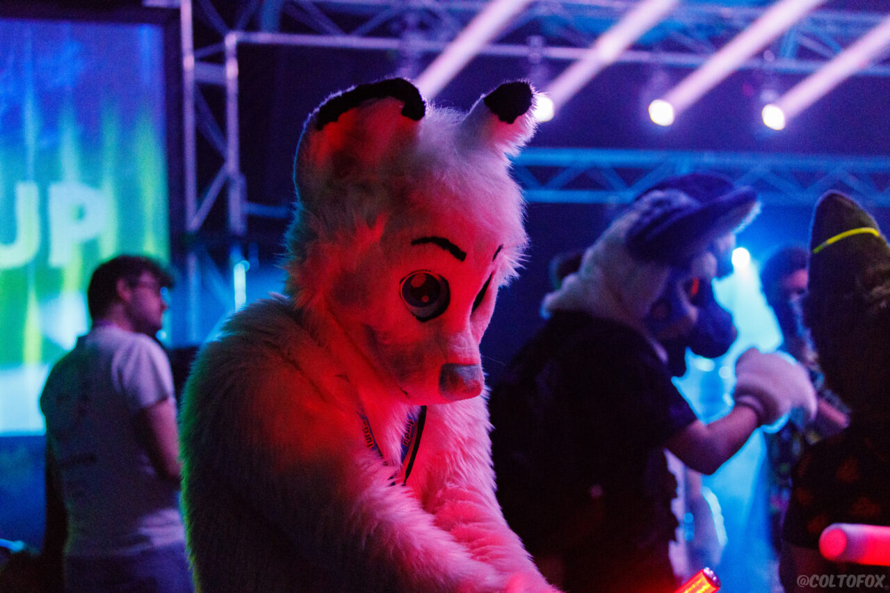 Kiri holding a red glow stick in a rave